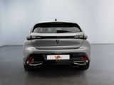 the rear end of a silver car in a white room