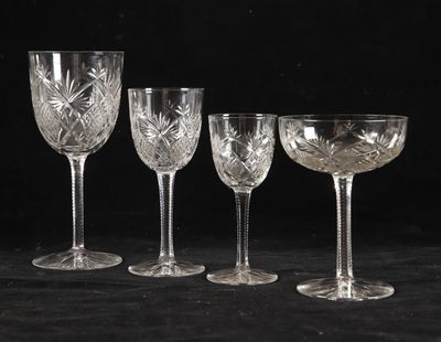 four wine glasses are lined up against a black background