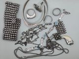 beaucoup de bijoux en argent sur une surface blanche