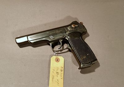 a gun with a tag attached to it sitting on a table