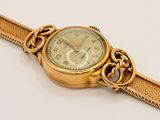 an image of a close up of a wrist watch with a chain around it
