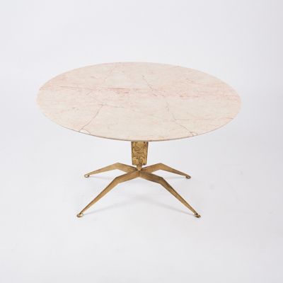 a round marble table with brass legs and a white marble top
