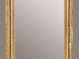 an antique gold framed mirror with a decorative design