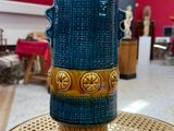 un vase bleu posé sur une table dans une pièce