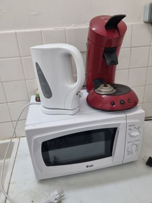 un micro-ondes et une cafetière posés sur un plan de travail