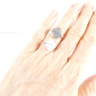 a woman ' s hand holding a ring with a stone on it