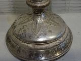 a silver plate with a candle on it on a table