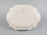 underside view of a white plate with a scalloped edge