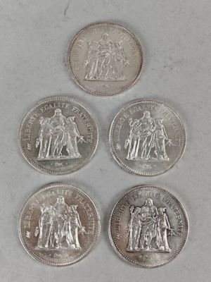 quatre types différents de pièces d'argent sur une surface blanche