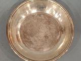 a silver plate on the table with a spoon in it