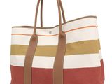 a striped tote bag on a white background with a brown handle