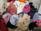 a pile of clothes that is on a bed