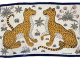deux guépards assis sur un tapis orné de fleurs et de feuilles