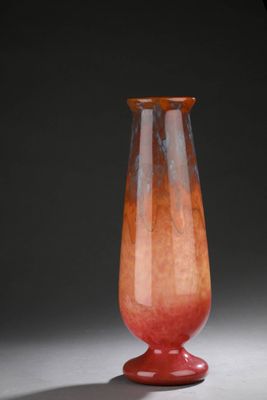 un vase en verre à la base rouge posé sur une table