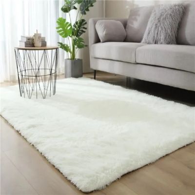 tapis blanc à poils longs dans un salon avec un canapé et une table