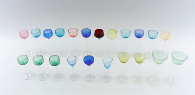 many different colored wine glasses lined up on a table