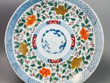un gros plan d'une assiette décorée de fleurs et de feuilles