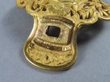 a close up of a gold brooch on a table