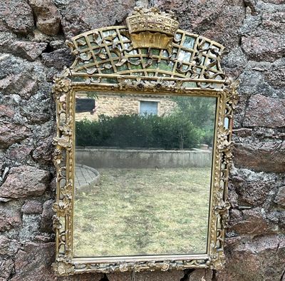 un miroir accroché à un mur de pierre, avec un mur de pierre derrière lui