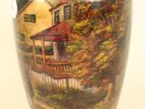 a vase with a painting of a house on it
