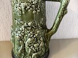 une grande tasse verte avec une anse, posée sur une table