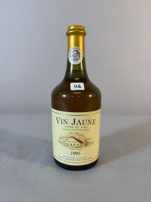 Des bouteilles de vin sont posées sur une table devant un fond blanc.