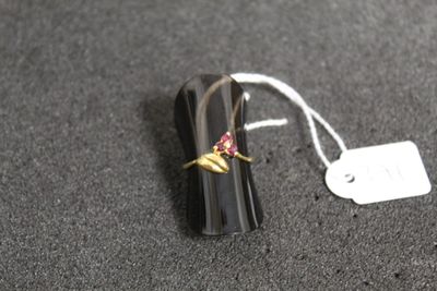 un petit objet noir orné d'une fleur rose
