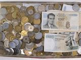 une boîte remplie de pièces et un billet sur lequel figure le portrait d'un homme