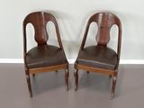 deux chaises en bois avec des assises rembourrées de cuir dans une pièce
