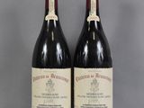 two bottles of wine sitting on top of a table next to each other
