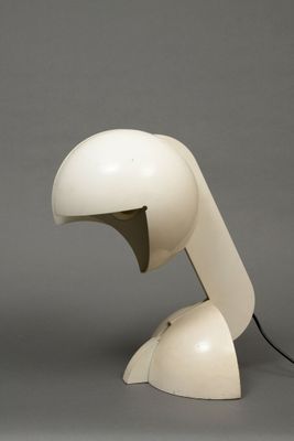 a white table lamp with a black cord on top of it