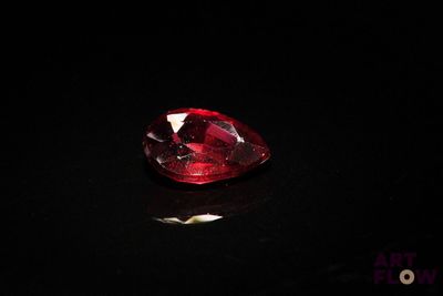a close up of a red diamond on a black surface