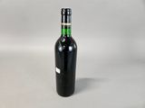 an empty bottle of wine sitting on top of a white table