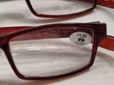 two pairs of red glasses sitting on top of a white table
