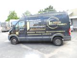 une camionnette garée sur un parking, avec d'autres véhicules en arrière-plan