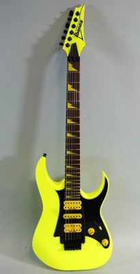 an electric guitar with a yellow body and a black neck
