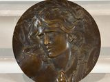 an image of a bronze plaque with a man ' s face