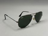 Des lunettes de soleil Ray-Ban posées sur une surface blanche, avec un fond blanc