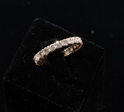 a gold ring with diamonds on top of a black velvet box