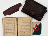 an old book with a leather case and a pair of scissors next to it