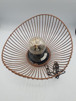 un panier en fil de fer contenant une lampe, posé sur une table