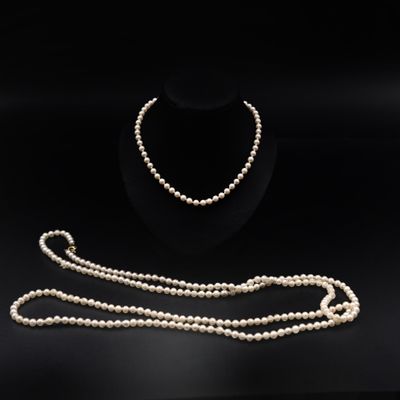 un ensemble composé d'un collier et d'un bracelet en perles blanches sur fond noir