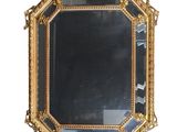 une image d'un miroir encadré d'or sur un fond blanc