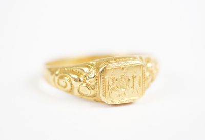 a close up of a gold signet ring on a white surface