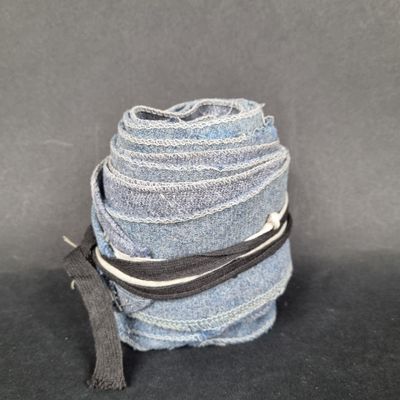 three pieces of blue jeans stacked on top of each other on a black surface