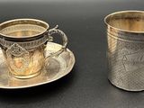 une tasse et une soucoupe argentées posées sur une table noire