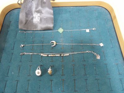 un sac contenant des bijoux posé par terre à côté d'une paire de ciseaux