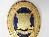 un gros plan d'une médaille posée sur une surface blanche, sur fond bleu