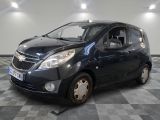the small black car is parked on a checkered tile floor