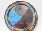 a silver plate with a picture of a woman on it